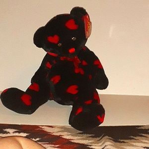 Black teddy bear with hearts